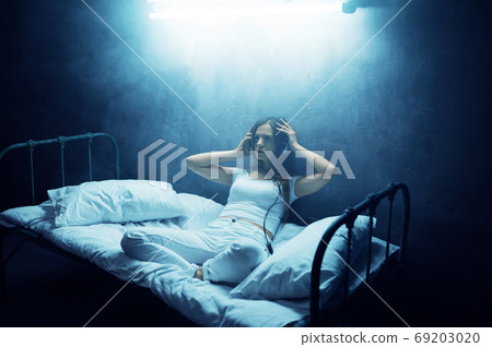 Crazy woman listens to music in bed, psychedelic 69203020