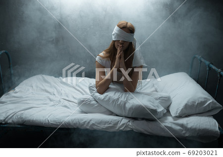 Blindfolded crazy woman in bed, psychedelic Blindfolded crazy woman in bed, psychedelic 69203021