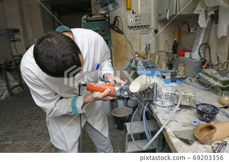 Worker cutting wooden blank with a hand cutting Worker cutting wooden blank with a hand cutting 69203356