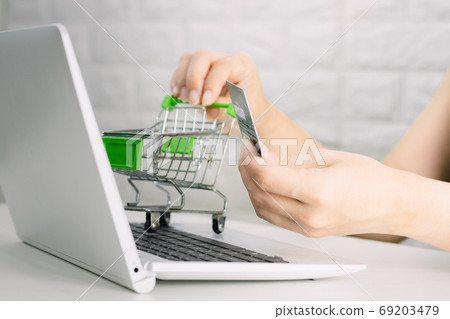 Hands holding credit card on the keyboard online shopping on lap Hands holding credit card on the keyboard online shopping on lap 69203479