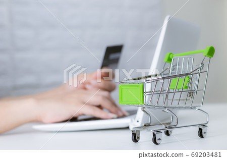 Hands holding credit card on the keyboard online shopping on lap Hands holding credit card on the keyboard online shopping on lap 69203481