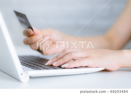 Hands holding credit card on the keyboard online shopping on lap Hands holding credit card on the keyboard online shopping on lap 69203484