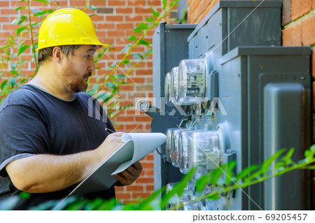 Electrical in yellow helmet technician writing 69205457
