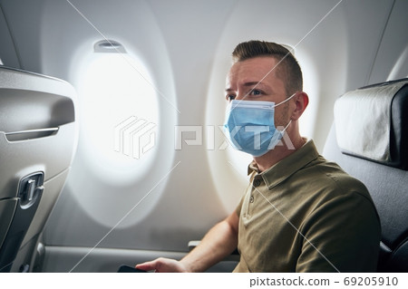 Man wearing face mask inside airplane 69205910