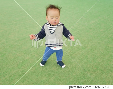 1 year old child standing on a lawn mat 1 year old child standing on a lawn mat 69207476