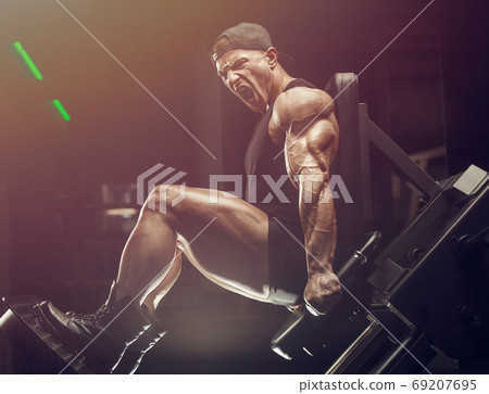 bodybuilder fitness man pumping up legs muscles 69207695