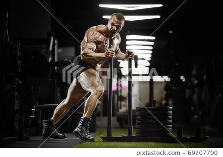 bodybuilder fitness man pumping up legs muscles bodybuilder fitness man pumping up legs muscles 69207700