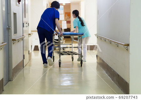 Medical worker pushing stretcher 69207743