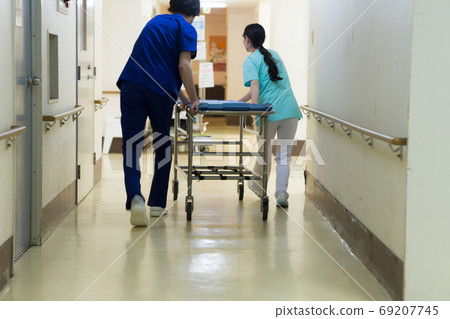 Medical worker pushing stretcher 69207745