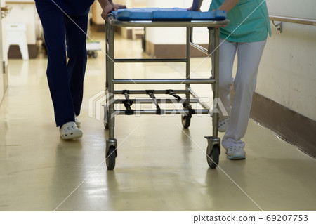 Medical worker pushing stretcher 69207753