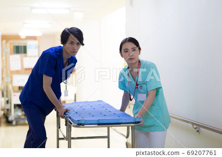 Medical worker pushing stretcher 69207761