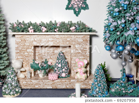 New Years holiday, fireplace with gifts, decorative Christmas trees, toys, balls and fir branches. New Years holiday, fireplace with gifts, decorative Christmas trees, toys, balls and fir branches. 69207956