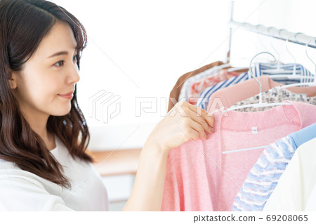 Smiling young woman choosing clothes 69208065
