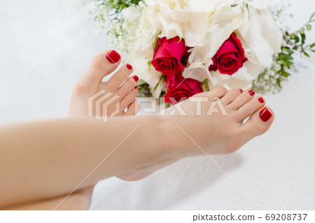 Feet of women with red toenails after pedicure Feet of women with red toenails after pedicure 69208737