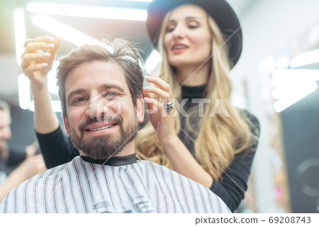 Man consulting woman hair stylist for advise on cut and styling Man consulting woman hair stylist for advise on cut and styling 69208743