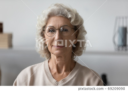 Head shot portrait confident mature woman wearing glasses at home 69209098