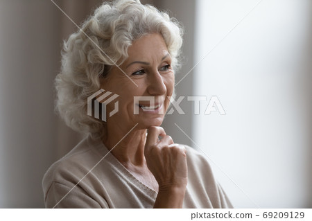 Close up smiling dreamy mature woman thinking about good future Close up smiling dreamy mature woman thinking about good future 69209129
