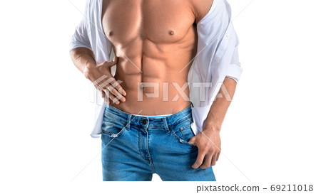 Muscular male torso in white shirt and blue jeans isolated on white. Cropped photo 69211018