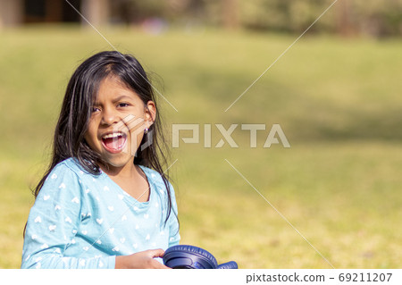 Little girl listening to music on the smartphone with her headph Little girl listening to music on the smartphone with her headph 69211207