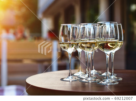 White wine tasting on winery terrace, pouring of cold dry wine in glasses outdoor in sunny day White wine tasting on winery terrace, pouring of cold dry wine in glasses outdoor in sunny day 69212007