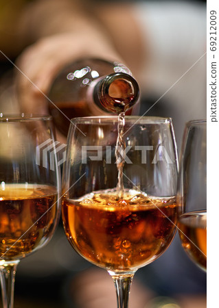 Close Up of Pouring Red Wine into Glass in Restaurant Setting Close Up of Pouring Red Wine into Glass in Restaurant Setting 69212009