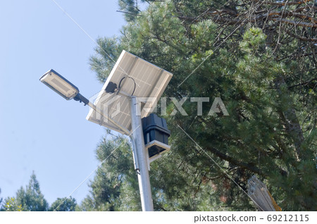 Photovoltaic Waterproof Aluminium make Solar Light in pine tree and blue sky background. Photovoltaic Waterproof Aluminium make Solar Light in pine tree and blue sky background. 69212115