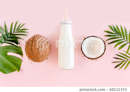 Pattern with coconuts and tropical palm leaves on pink background. Tropical abstract background. Flat lay, top view. Pattern with coconuts and tropical palm leaves on pink background. Tropical abstract background. Flat lay, top view. 69212353