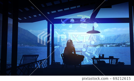 A writer works on a laptop after sunset. 69212615