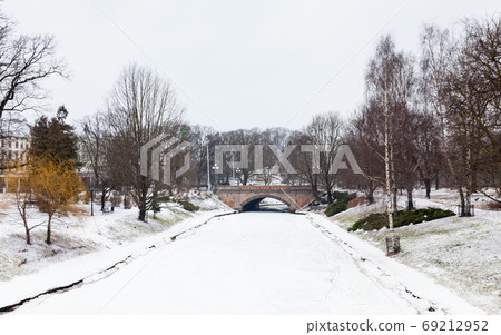 Riga Canal. A winter view along a frozen Riga canal. The canal flows through Bastion Hill park in Riga, Latvia. 69212952