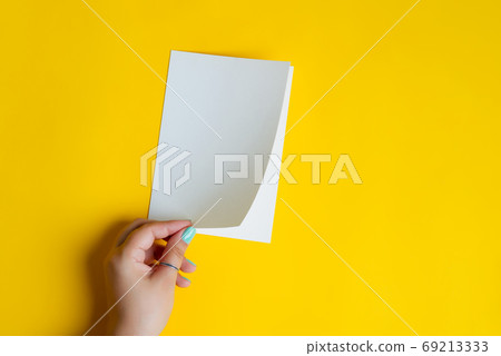 White mockup paper brochure in a woman's hand. White mockup paper brochure in a woman's hand. 69213333