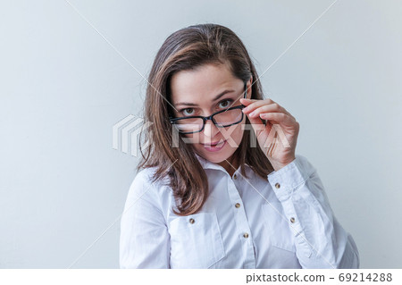 Beautiful happy girl smiling. Beauty simple portrait young smiling brunette woman in eyeglasses isolated on white background. Positive human emotion facial expression body language. Copy space Beautiful happy girl smiling. Beauty simple portrait young smiling brunette woman in eyeglasses isolated on white background. Positive human emotion facial expression body language. Copy space 69214288