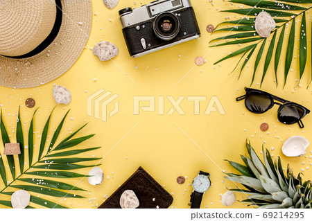 Traveler accessories, tropical palm leaf branches on yellow background with empty space for text. Summer background. Flat lay, top view. Traveler accessories, tropical palm leaf branches on yellow background with empty space for text. Summer background. Flat lay, top view. 69214295