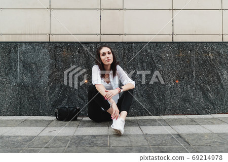 Young woman resting on the asphalt. 69214978