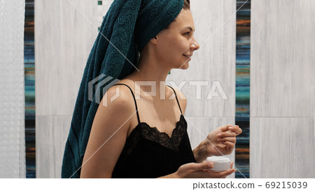 Happy woman in the bathroom with towel on her head Happy woman in the bathroom with towel on her head 69215039