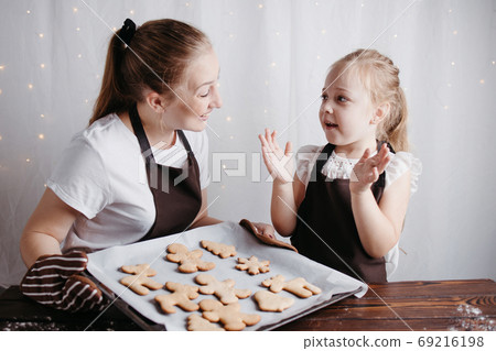 Mother and daughter cooking christmas sweets 69216198
