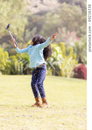 Little girl taking a picture with an action camera Little girl taking a picture with an action camera 69216336