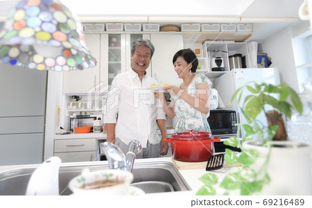 Working from home A couple who are good friends standing in the kitchen Fun cooking Hobbies Working from home A couple who are good friends standing in the kitchen Fun cooking Hobbies 69216489