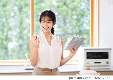 A woman using a tablet in the kitchen 69217262