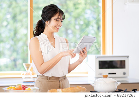 使用片劑的一名婦女在廚房裡 69217265