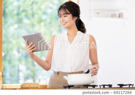 使用片劑的一名婦女在廚房裡 69217266