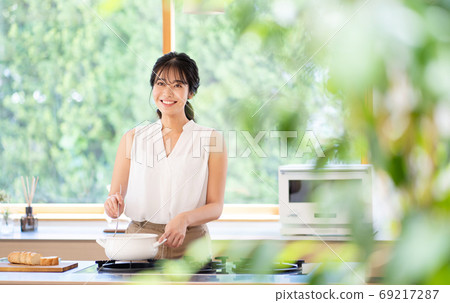 年輕女子在廚房做飯 年輕女子在廚房做飯 69217287