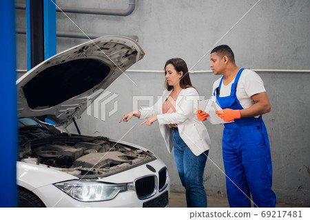 Customer asks mechanic to fix car engine Customer asks mechanic to fix car engine 69217481