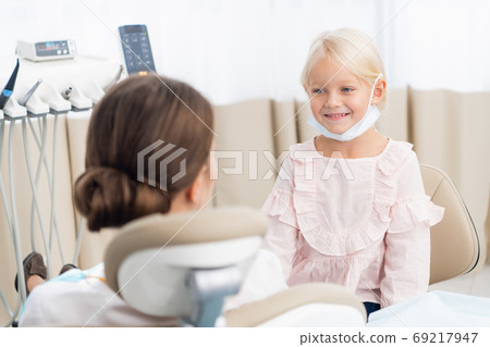 Beautiful brunette female doctor with her little patient Beautiful brunette female doctor with her little patient 69217947