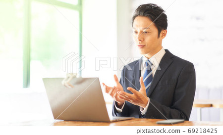 Man having a video chat towards the PC Man having a video chat towards the PC 69218425