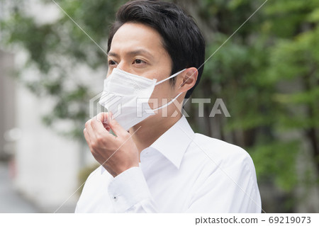 Japanese businessman in his thirties wearing a mask Japanese businessman in his thirties wearing a mask 69219073