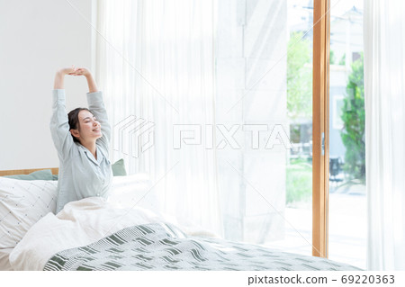 Women stretching in bed Women stretching in bed 69220363