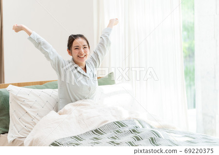 Women stretching in bed Women stretching in bed 69220375