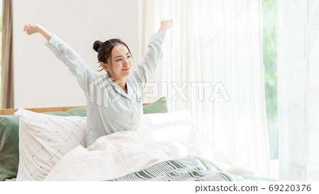Women stretching in bed Women stretching in bed 69220376