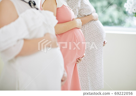 Pregnant women touching bellies 69222056