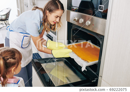 Housewife taking out cake Housewife taking out cake 69222075